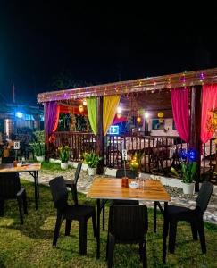a patio with tables and chairs at night at 3 J'S Homestay in Carles