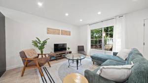 a living room with a blue couch and a tv at The Oasis - 2 Private Homes, Pool, and BBQ in New Port Richey