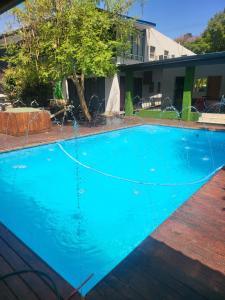 a large blue swimming pool in front of a house at THK Properties in Pretoria