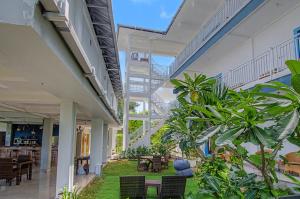 a building with a courtyard with tables and chairs at Hotel Bonne Nuit in Labuan Bajo +13 photos