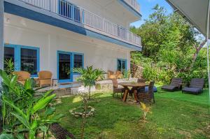 a patio with a table and chairs in a yard at Hotel Bonne Nuit in Labuan Bajo