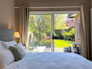 a bedroom with a bed and a large window at sweet home in Richmond