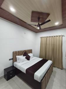 a bedroom with a bed with a ceiling fan at Hotel Staywell in Karnal +4 photos