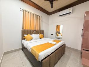 a bedroom with a large bed with an orange blanket at Hotel Staywell in Karnal