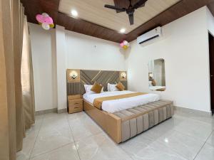 a bedroom with a large bed and a ceiling fan at Hotel Staywell in Karnal