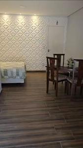 a room with a table and chairs and a bed at Chácara Minas Garten in Jundiaí