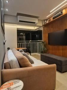 a living room with a couch and a flat screen tv at APTO 42M l 7 km Alphaville in Osasco