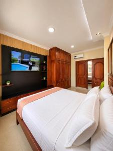 a bedroom with a large bed and a flat screen tv at Suite Matrimonial con Piscina Desayuno Ambiente Exclusivo in Machala