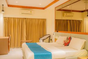 a hotel room with a bed and a chair at Hotel Prince Residency, Bhuj in Bhuj