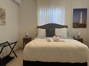 a bedroom with a bed with two stuffed animals on it at Villa Fina Aruba in Palm-Eagle Beach