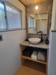 a bathroom with a sink and a mirror at Rinku Base Ichi in Tajiri