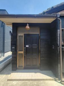 a front door of a house with a brown door at Rinku Base Ichi in Tajiri