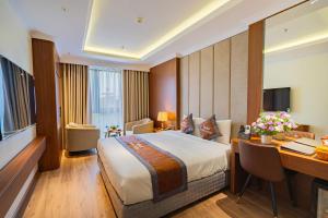 a hotel room with a bed and a desk with a computer at Aroma Hotel An Khánh in Vân Lũng +29 photos