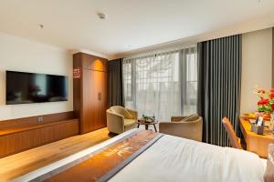 a hotel room with a bed and a flat screen tv at Aroma Hotel An Khánh in Vân Lũng