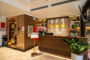 a restaurant with a counter with flowers on it at Aroma Hotel An Khánh in Vân Lũng