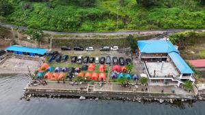 an aerial view of a restaurant with umbrellas and cars at Casmel Escape Hostel in Silalahi