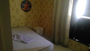 a small bedroom with a bed and a television at wowspa in Ajman 