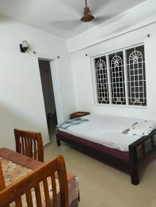 a bedroom with a bed and a table and a window at Sky Loft in Trivandrum