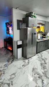 a kitchen with silver appliances and marble floors at Casa Lujosa in Choluteca