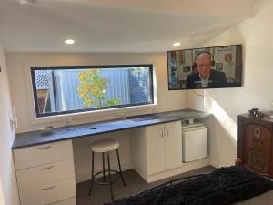 a home office with a desk and a large screen television at Kaiapoi Village Le Shack in Kaiapoi