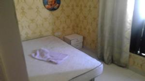a small bedroom with a bed with a purple sheet on it at wowspa in Ajman 