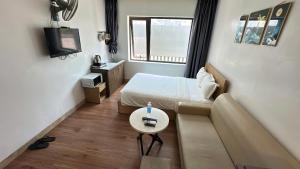 a small room with a bed and a couch at Salux Hotel in Danang