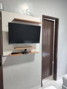 a flat screen tv on a wall in a living room at Fênix Hotel Colinas do Tocantins in Colinas do Tocantins