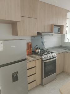 a kitchen with a stove and a refrigerator at departamento familiar privado trujillo huanchaco in Huanchaco