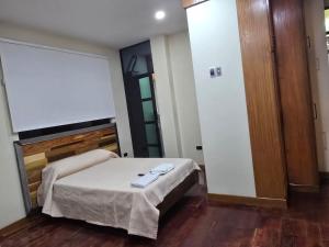 a small room with a bed and a mirror at RoofTop8 in Cochabamba