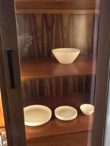 a shelf with three white plates and bowls on it at RoofTop8 in Cochabamba