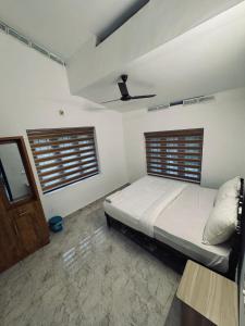 a bedroom with a bed and a ceiling at Chills homestay in Kalpetta