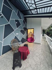 a room with a table and chairs and a wall at Chills homestay in Kalpetta