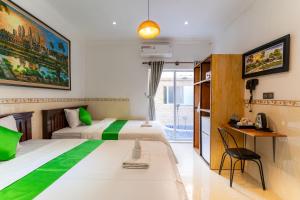 a hotel room with two beds and a desk at 855 Villa Siem Reap in Siem Reap +31 photos