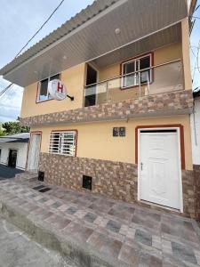 a house with a white door in front of it at Hostal Ruta Cafetera in La Tebaida