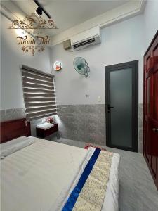 a bedroom with a large bed and a fan at Nhà nghỉ Thanh Thư 2 in Vị Thanh