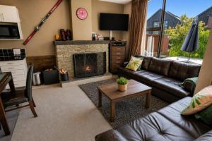 a living room with a couch and a fireplace at Cardrona Sanctuary by Aotearoa Escapes in Cardrona