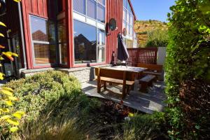 a house with a table and a bench in front of it at Cardrona Sanctuary by Aotearoa Escapes in Cardrona