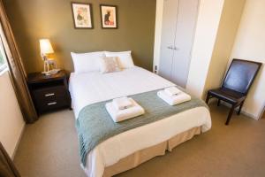 a bedroom with a bed with two towels on it at Cardrona Sanctuary by Aotearoa Escapes in Cardrona