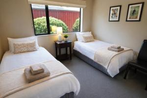 two beds in a room with a window at Cardrona Sanctuary by Aotearoa Escapes in Cardrona +16 photos