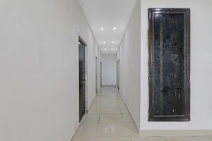 an empty hallway with a door and a tile floor at Hotel O Rudra Palace Near Phoenix United Lucknow in Alambagh