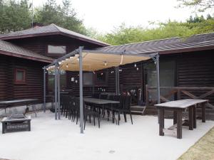 a patio with tables and chairs in front of a cabin at スターダスト高山 in Nakayama