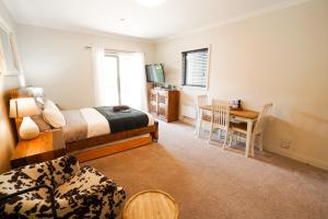 a bedroom with a bed and a table and chairs at Cardrona Ridge by Aotearoa Escapees in Cardrona