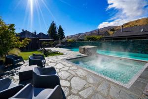 a swimming pool in a backyard with chairs around it at Cardrona Ridge by Aotearoa Escapees in Cardrona