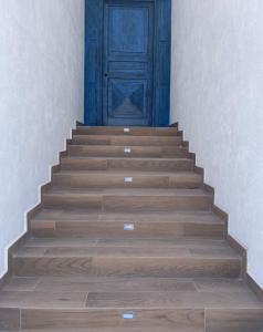 a wooden staircase with a blue door in a building at Casa Puerto Azul in San Carlos