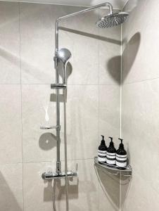 a shower with three black bottles on a shelf at Stay in WAVE in Ch'ŏngsap'o +34 photos