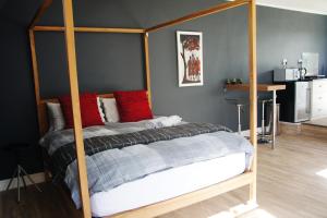 a bedroom with a canopy bed with red pillows at Villa Barry in Hout Bay