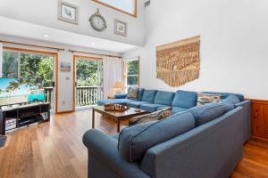 a living room with a blue couch and a television at 1602 - Here To Stay in Corolla