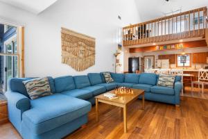 a living room with a blue couch and a table at 1602 - Here To Stay in Corolla +48 photos