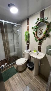 a bathroom with a toilet and a sink and a shower at Hospedaje Salento in Salento