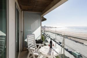 a balcony with a table and chairs and a view of the beach at SEAMatosinhos in Matosinhos